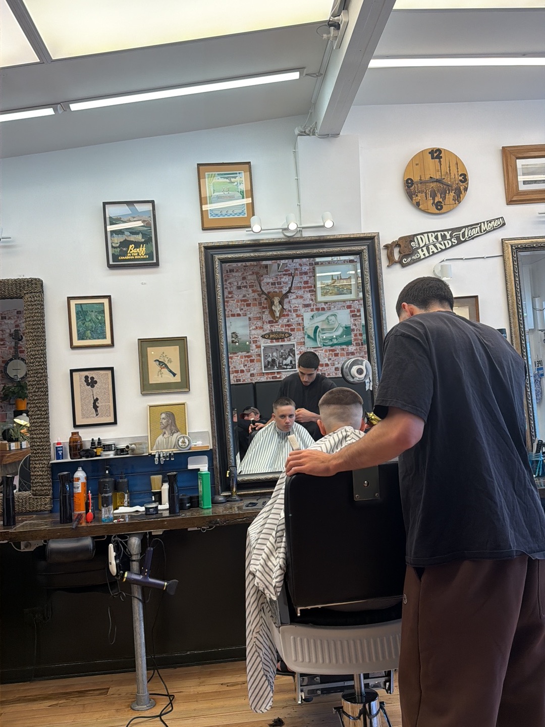 Sebastian cutting a young client's hair inside the barbershop